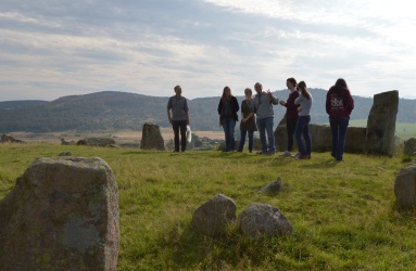 Group standing in front of recumbent stone in stone circle