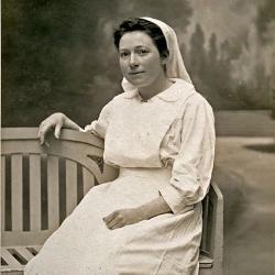 Amelia Nyasa Laws sitting on a bench in a nurses uniform, sepia toned.