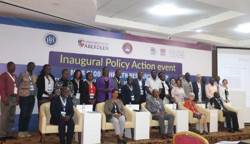 Group photo of attendees in front of event banner.