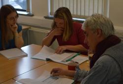 Three people sitting around a table in class