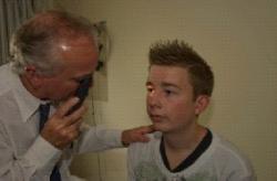 Image of patient being examined with an ophthalmoscope by Professor Forrester