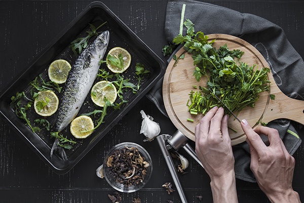 Hands cutting parsley to garnish fish