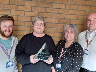 On-site team with Outcomes Award Trophy