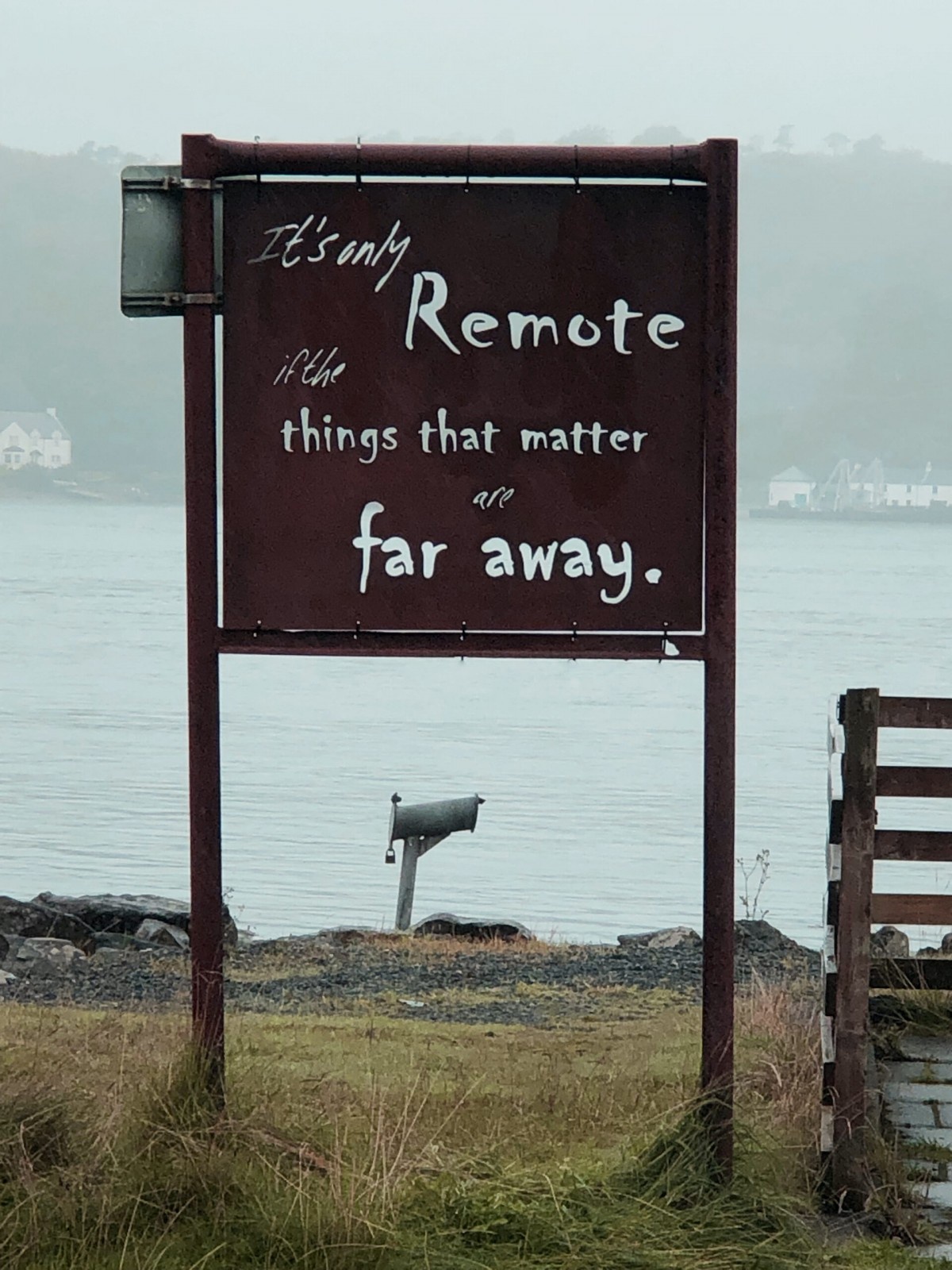 Rusted signpost in a rural seaside location bearing the message 'It's only remote if the things that matter are far away'.