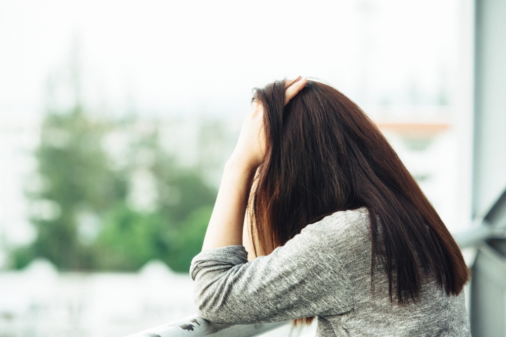 Woman with head down alone and upset