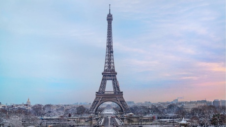 an image of the Eiffel Tower in winter with the city below covered in snow