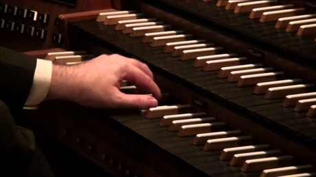 Colour picture of a hand on an organ keyboard