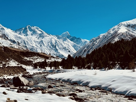 Image of mountains covered in snow with a river running through