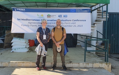Katrin Prager and Harun Cicek in front of information banner