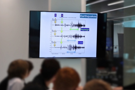 A screen displays two different types of seismic waves and demonstrates the difference between the two.  The seismic waves are labelled "Rayleigh" and "Love"