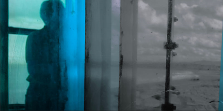 Abstract image of a person silhouetted behind blue and grey glass