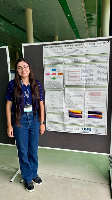 Ana Paula da Silva Koltun standing with her poster at the XLIV Dynamics Days Europe