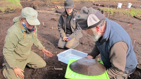 Drs Hillerdal, Forbes and Knecht remove a large wooden bowl from the site