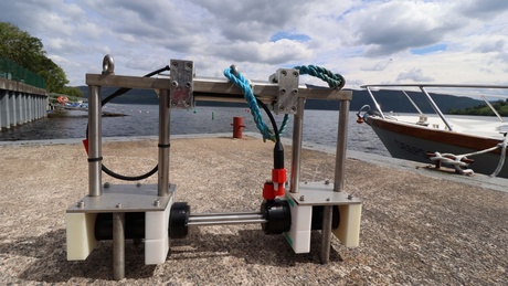 A mechanical structure sat on the pier of a loch