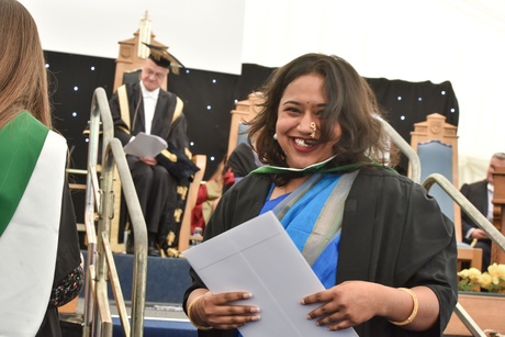 Woman smiling as she collects her certificate
