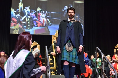 A man in a kilt onstage