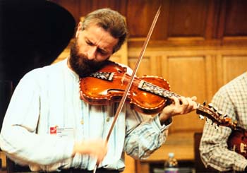 Bearded man playing ornate Hardanger fiddle