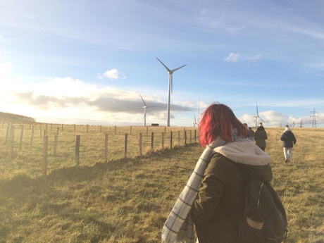 people in front of windmills with blue skye and sunshine