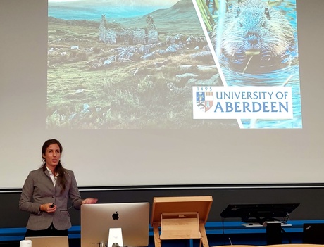 Flurina Wartmann presenting in front of a picture of a croft and a beaver