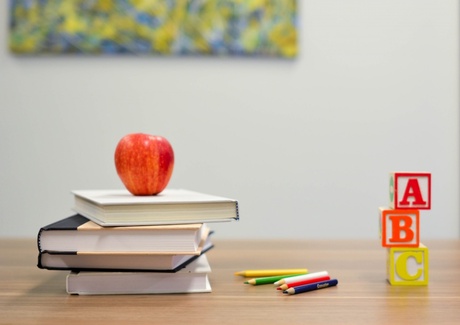 A table with books and and apple