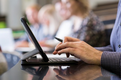 An image of a student taking notes on a lap top