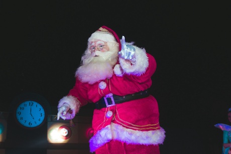 santa claus standing near to a clock