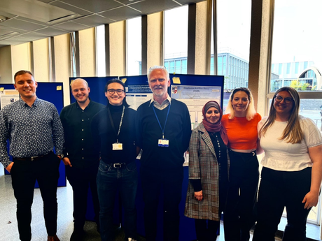 Prize winners standing in front of posters.