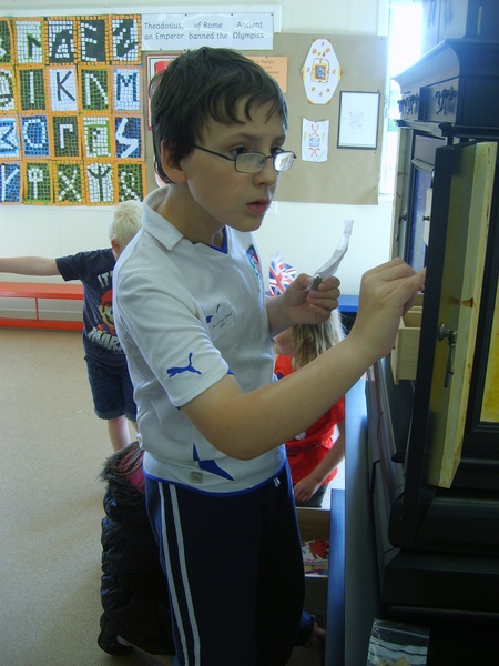 Finnan Grant of Oyne School helping to organise the display in the Cabinet of Curiosities