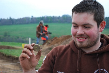 Student Robert Lang with spindle whorl from the possible building site near the Craw Stane at Rhynie