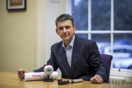 Professor Alexandros Zangelidis with eye charts and equipment