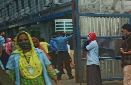 Image of male and female garment workers outside a factory in Bangladesh