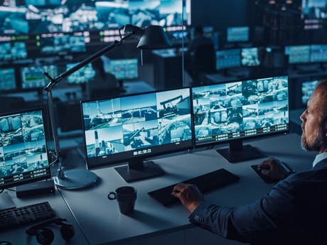 Male operative at a bank of CCTV monitors