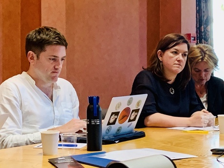 A man and two women sitting at a table with laptops