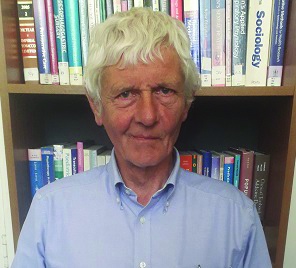 Head and shoulders shot of David sitting in front of a book case