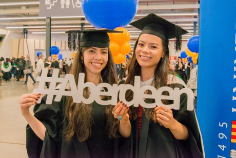 Happy graduates holding up Aberdeen sign