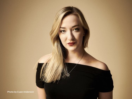 Head and shoulders shot of a blonde woman in a black top