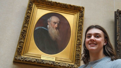 Alison Ritchie stands in front of a portrait of her great, great, great grandfather - Professor David Rennet, a professor of Maths at the University of Aberdeen in the 1800s