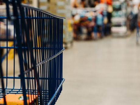 A shopper pushing a trolley through a supermarket