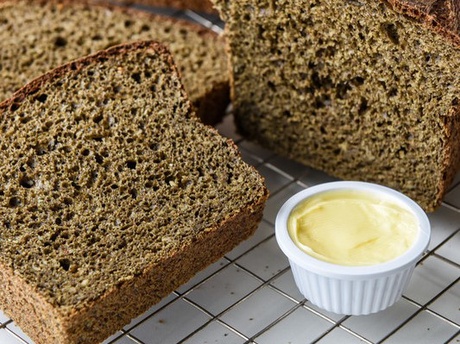 bread cooling on a wire rack next to some butter