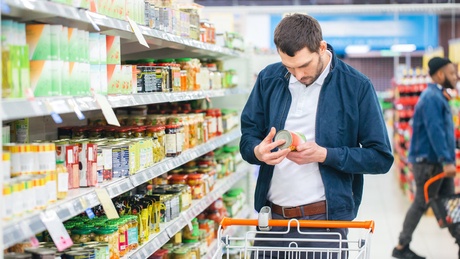 Man looking at labels in supermarket