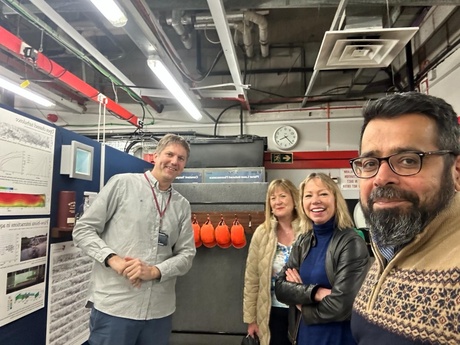 Staff posing with posters in the background