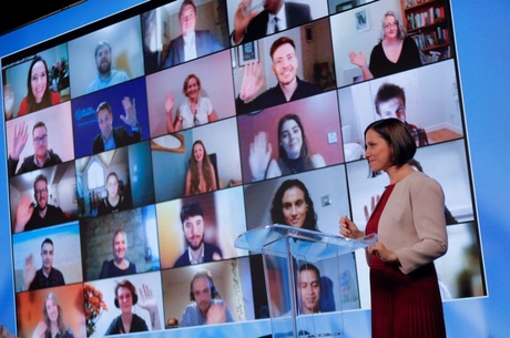 Converge director in front of a screen of project participants