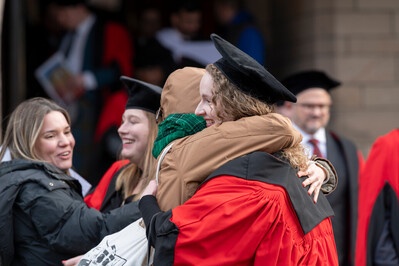 Two people hugging outside Elphinstone Hall