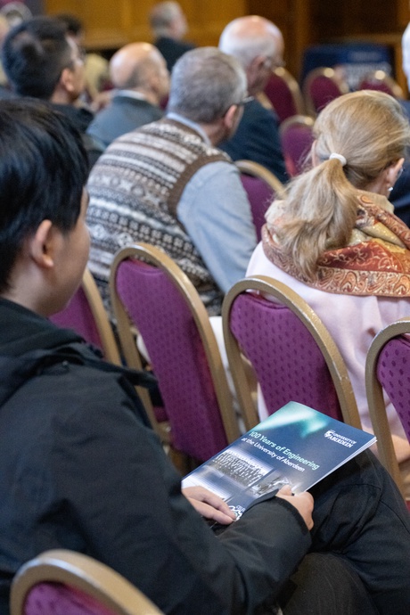 Close up[ of an audience member holding an event brochure