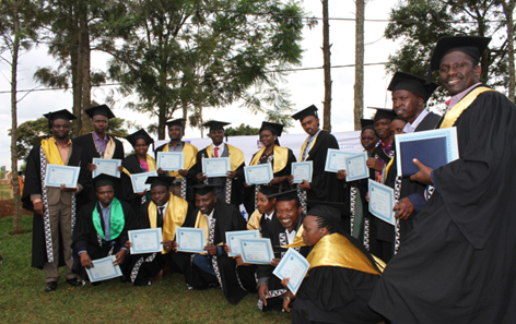 Photo of group of people in graduation hats and gowns holding certificates.