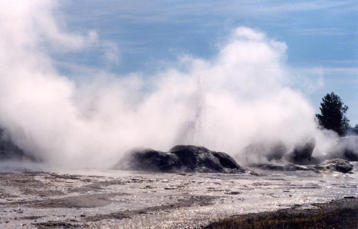Geysers in eruption at Yellowstone National Park. Precipitation of amorphous silica from successive eruptions and outflows of hot water create 'cones' and sheets of sinter around the vent.