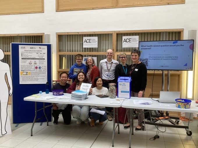 A group photo of ACE members behind their Doors Open Day information stand