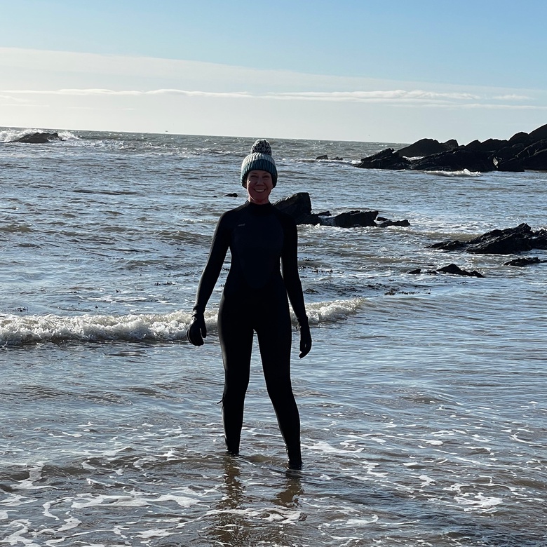 Christine Mackenzie in a wetsuit on a beach