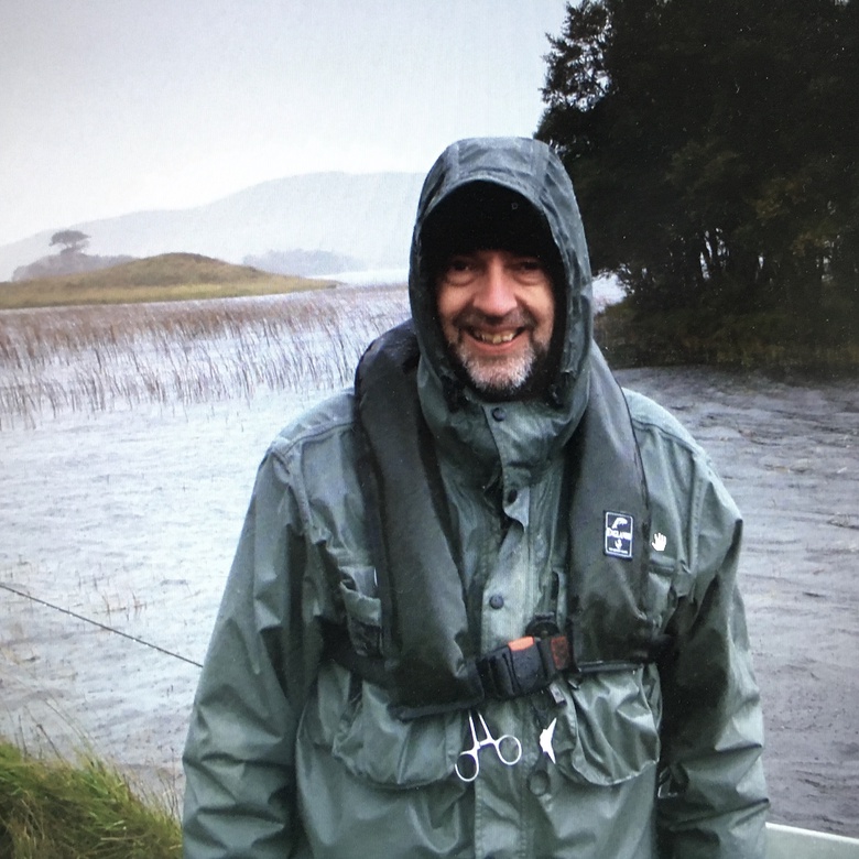 Kevin Mackenzie wearing a raincoat near a body of water