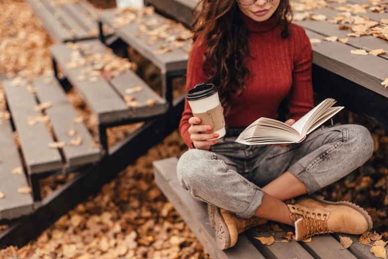 Woman reading holding hot drink